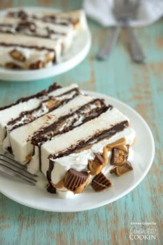 a piece of ice cream cake on a plate with a fork and spoon in front of it