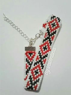 two bracelets with red, black and white beaded designs hanging from silver chains