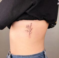 a woman's stomach with a flower tattoo on her lower side ribcage