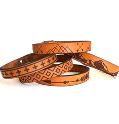 three leather bracelets with native designs on them