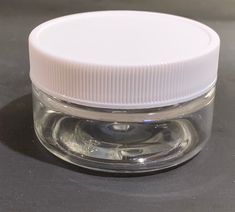 a clear jar with white lid sitting on a table