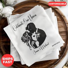 personalized wedding napkins with bride and groom silhouette on them, sitting on a wooden platter