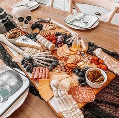 a wooden table topped with lots of cheese and meats