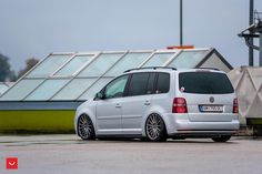 a white vw golf wagon parked in front of a building