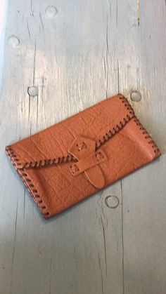 a brown leather wallet sitting on top of a wooden table