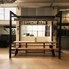 a table and bench in an office with the word officine zero on it