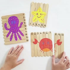 children's hands are playing with wooden pegs and numbers to match the animals