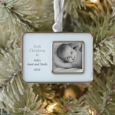 a baby's first christmas ornament hanging from a tree