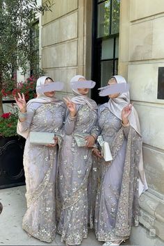 three women dressed in matching outfits standing next to each other