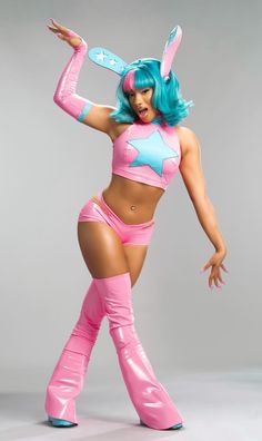 a woman dressed in pink and blue is posing with her arms out to the side