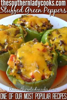 stuffed green peppers with cheese and other toppings are on a white plate in front of a wooden table