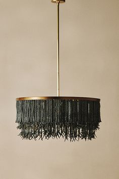 a chandelier hanging from the ceiling with fringes on it's sides