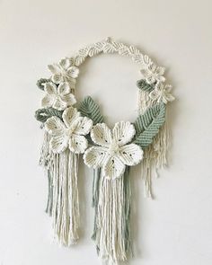 a white wall hanging with flowers and tassels