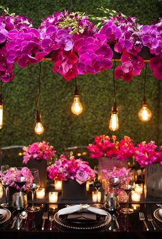 the table is set with purple flowers and candles