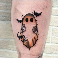 a man's leg with a tattoo on it that has a ghost and bats