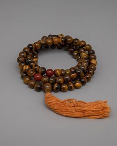 AAA Grade Tiger Eye Japa Mala About our Mala beads Our AAA Grade Brown Tiger Eye Japa Mala handcrafted with 8mm beads, represents spiritual strength and grounding. Each bead, infused with the captivating colors of brown Tiger Eye, exudes protection and vitality, guiding you on a journey of inner transformation and empowerment. Carnelian dividers are delicately incorporated into this mala, adding to its beauty and functionality by providing a seamless transition between beads and infusing your me Spiritual Gemstone Beaded Bracelets For Meditation, Holistic Round Beaded Bracelets For Meditation, Holistic Beaded Bracelets For Meditation, Holistic Wooden Beaded Bracelets For Meditation, Holistic Healing Mala With Wooden Beads, Holistic Beaded Bracelets With Round Beads For Meditation, Spiritual Wooden Beads Jewelry For Meditation, Spiritual Brown Mala For Healing, Spiritual Mala With 108 Beads For Blessing