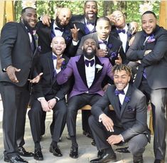 a group of men dressed in tuxedos posing for a photo with each other