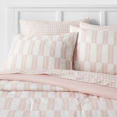 a bed with pink and white checkered sheets