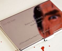 a silver business card case with a man's face and blood on the floor