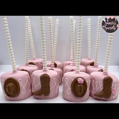 there are many pink candy jars with chocolates in them and decorated like camera's