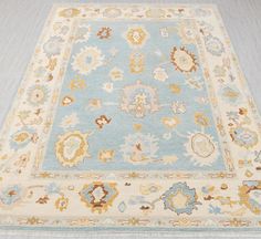 a light blue and beige rug with an intricate design