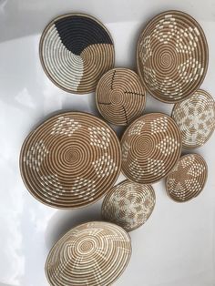 several woven baskets are arranged on a white surface with black and brown circles in the middle