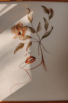 a drawing of a woman's face with leaves and flowers in her hair on a sheet of paper