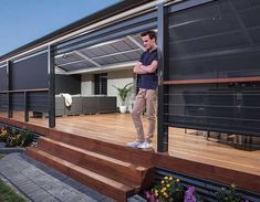 a man is standing on the steps outside his house, looking out onto the yard