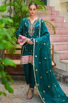 This festive silhouette is cut from cotton net in a vibrant emerald green and is detailed with gota and floral embellishments. The peacock motifs add a uniqueness to this versatile ensemble. The look is completed with an organza dupatta with dispersed  gota flowers and a matching rawsilk shalwar. Marriage Suit, Marriage Suits, Sania Maskatiya, Canada Style, Peacock Motifs, Peacock Color, After Marriage, The Peacock, Peacock Green