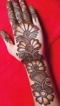 a woman's hand with henna tattoos on it