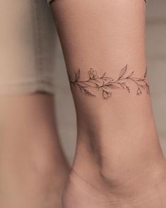 a woman's foot with a flower tattoo on the left side of her ankle