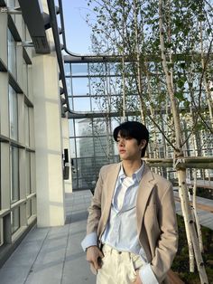 a young man is standing in front of a building