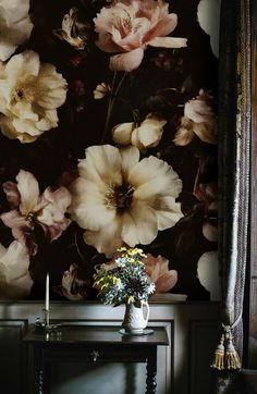 a vase filled with flowers sitting on top of a wooden table next to a window