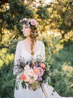 a woman wearing a white dress holding a bouquet of flowers in her hand and looking off into the distance