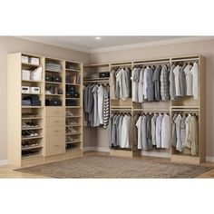 a large white closet with clothes and shoes on it's shelves in front of a beige wall