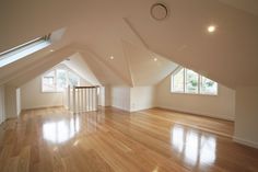 an empty room with hard wood floors and skylights on the windows above it is shown