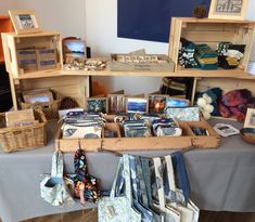 the table is covered with many items for sale in baskets and on top of cloths