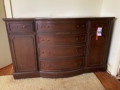 a large wooden dresser sitting on top of a carpeted floor