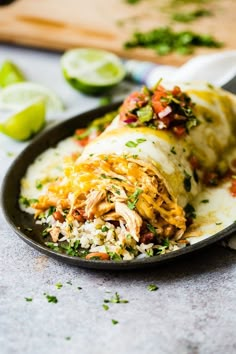 a close up of a burrito on a plate with rice and cilantro