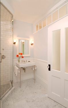 a bathroom with a sink, mirror and shower