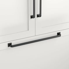 a white cabinet with two black handles on it