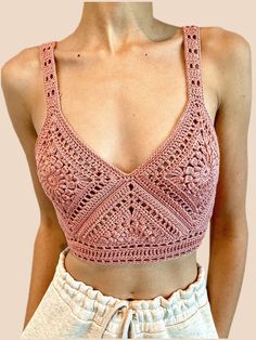 a woman wearing a pink crochet top and shorts