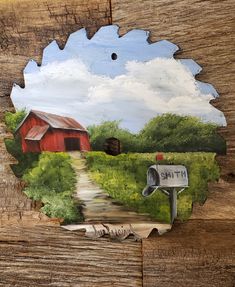 a piece of wood with a painting of a red barn on it's side