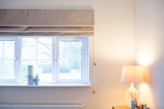 a bedroom with a lamp, window and radiator on the side table in front of it