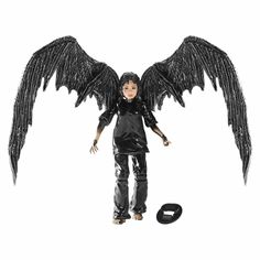 a doll with black wings standing next to a ball