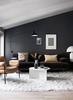 a living room filled with furniture and a white rug on top of a hard wood floor