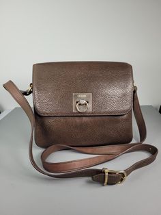 Introducing a stunning vintage Celine crossbody bag in a beautiful khaki leather finish. This medium-sized bag boasts a solid pattern and a rectangular shape with a clasp closure. The bag features a crossbody strap with a drop of 57cm (22.4"), making it convenient for everyday wear.   The interior lining is made of brown fabric, and the bag has a depth of 7cm (2.8"). The bag is designed with gold hardware, and the strap is made of leather. The bag is 22cm (8.7") in width and 19cm (7.5") in heigh Vintage Rectangular Flap Bag For Evening, Vintage Evening Flap Bag Rectangular, Vintage Rectangular Evening Flap Bag, Vintage Evening Bag With Turn-lock Closure, Vintage Evening Flap Bag, Vintage Rectangular Flap Bag With Adjustable Strap, Vintage Flap Bag With Detachable Strap For Formal Occasions, Brown Rectangular Bag With Turn-lock Closure, Brown Rectangular Satchel With Turn-lock Closure