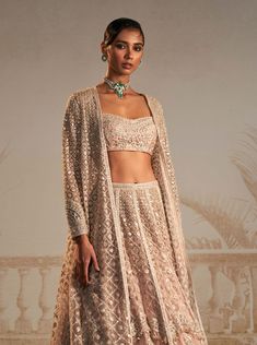 Elevate your festive style with this stunning champagne lehenga set. This exquisite ensemble includes a sparkling champagne heavy lehenga paired with a beautifully embroidered bustier and a chic long jacket. The floral motifs add a touch of grace and charm to the ensemble, making it perfect for any occasion where you want to make a lasting impression. The seamless blend of traditional craftsmanship and contemporary design ensures that you'll turn heads effortlessly. Lehenga With Long Jacket, Champagne Lehenga, Embroidered Bustier, Heavy Lehenga, Ridhi Mehra, Kurta Lehenga, Lehenga Pattern, Sparkling Champagne, Lehenga Wedding