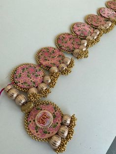 a row of pink and gold buttons on a white surface