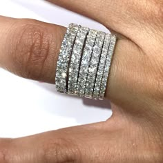 a woman's hand with three rows of diamond rings on top of her finger